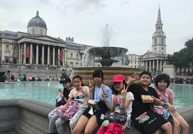 同學在倫敦特拉法加廣場噴水池旁享用午餐,背後是國家美術館和聖馬田教堂 | 英國遊學團