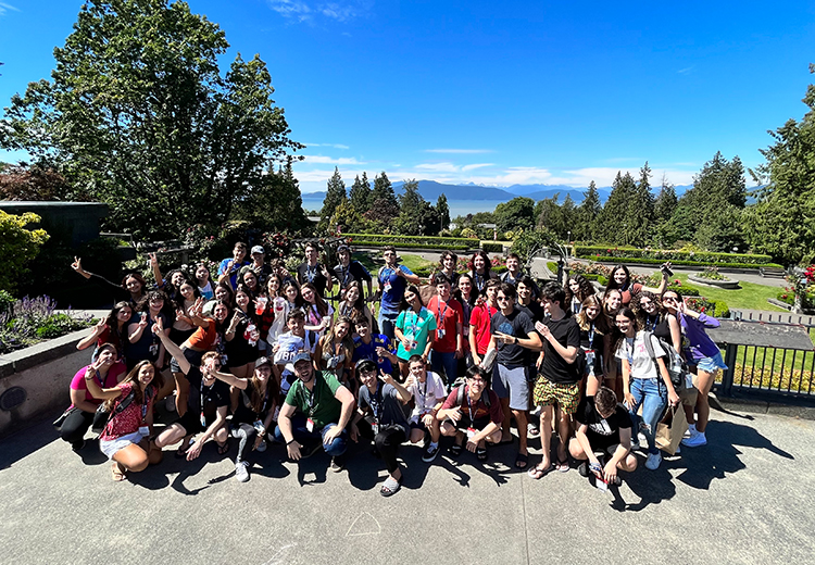 同學在加拿大不列顛哥倫比亞大學植物園合照，背景是壯麗山景與藍天白雲，展現夏日探索自然與學術交流的樂趣 | 加拿大遊學團